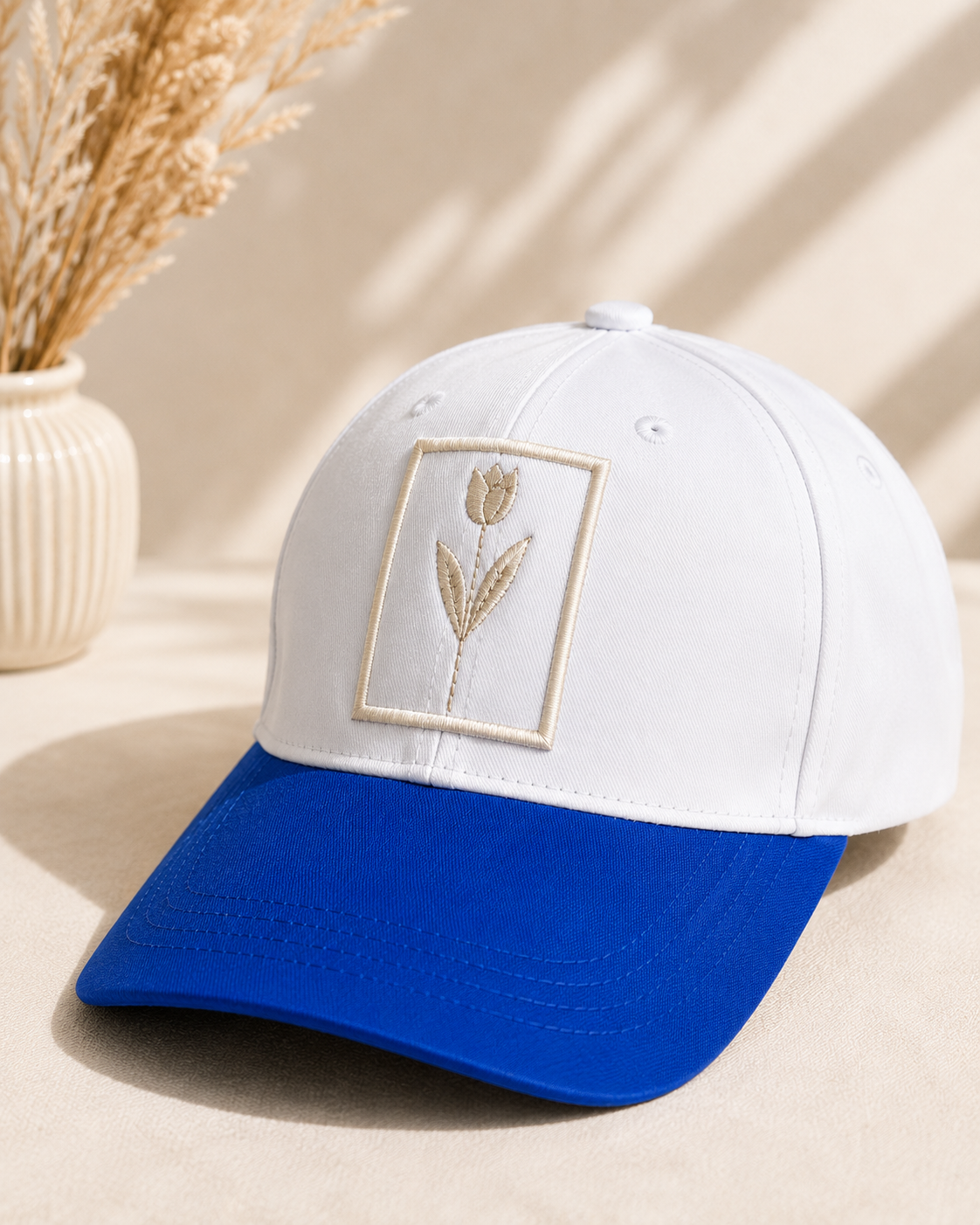White and blue embroidered baseball cap with minimalist floral patch design