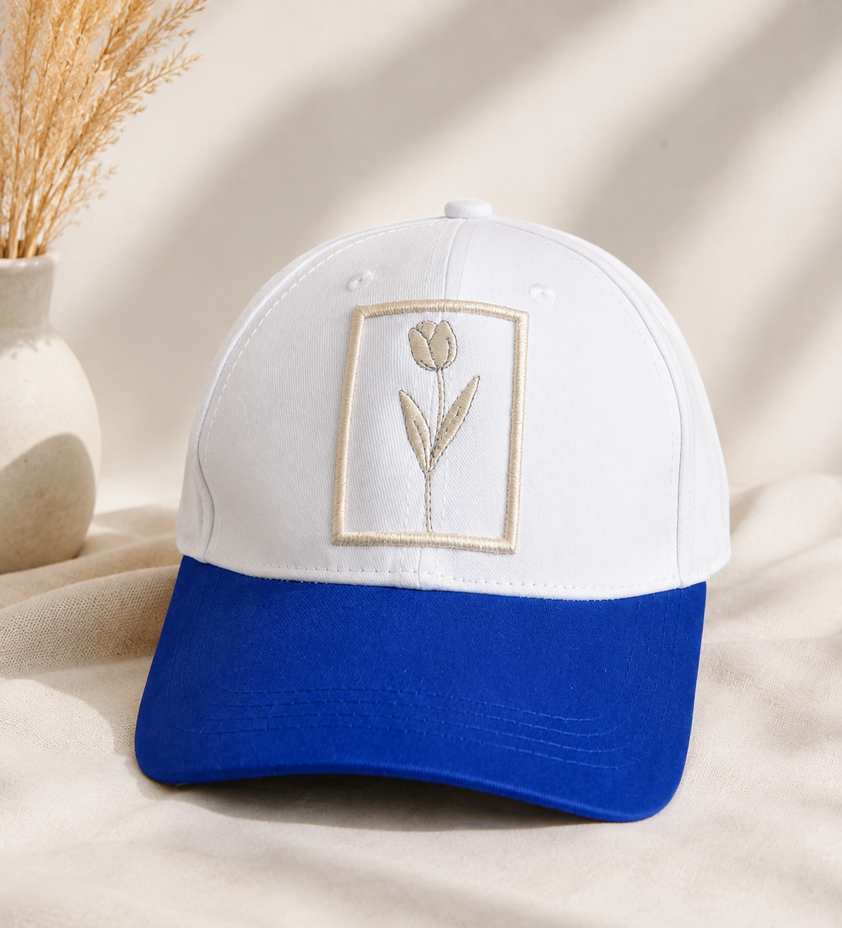 White and blue embroidered baseball cap with floral patch design