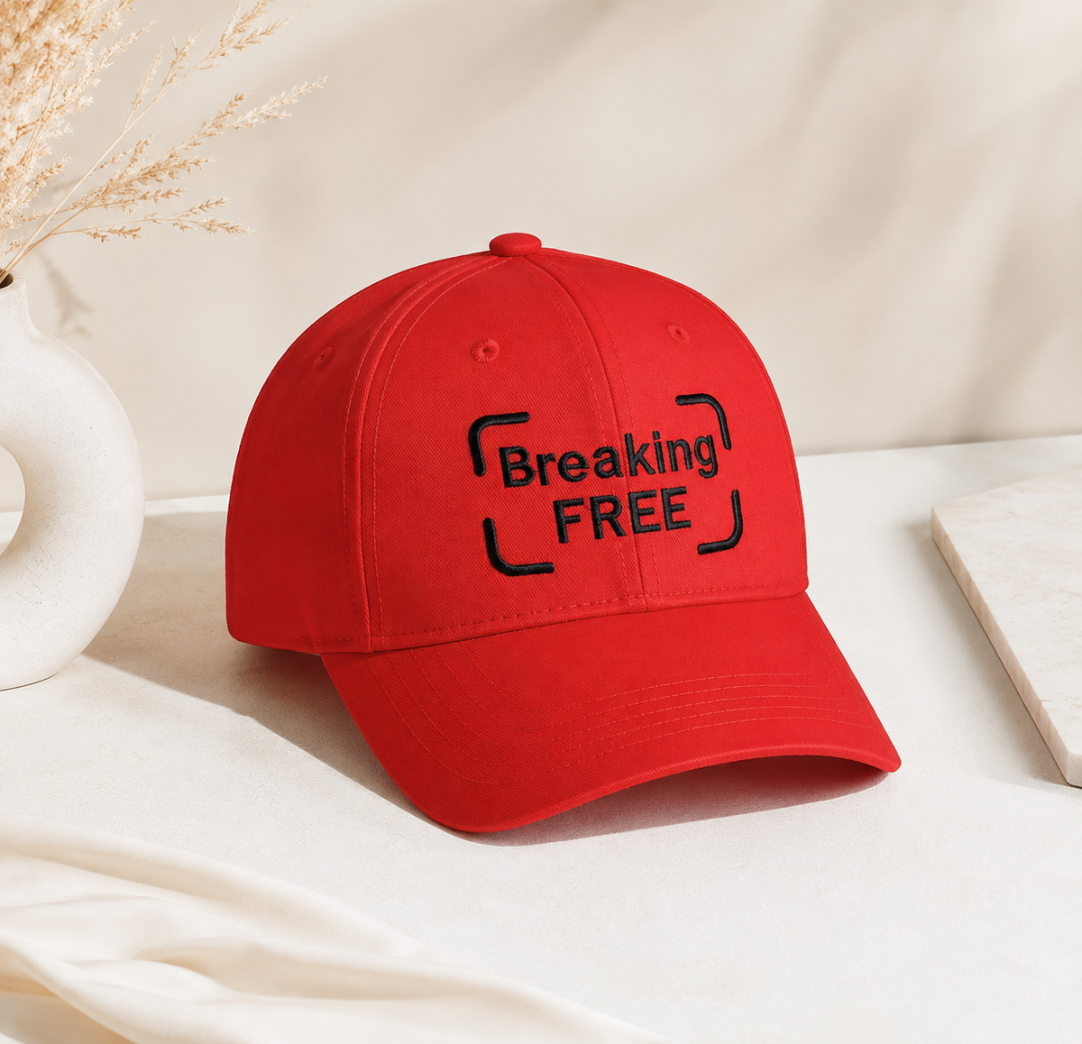 Red embroidered baseball cap with Breaking Free slogan